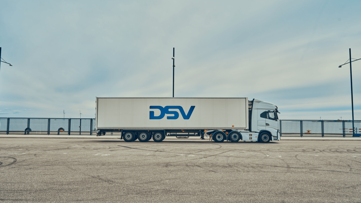 DSV-trailer står parkert på en stor parkeringsplass ved vannet.